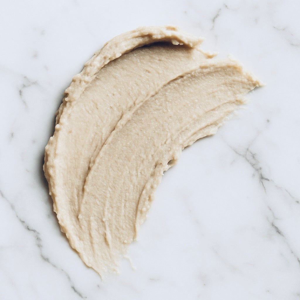 a soft smear of deodorant on a light white and grey marble background
