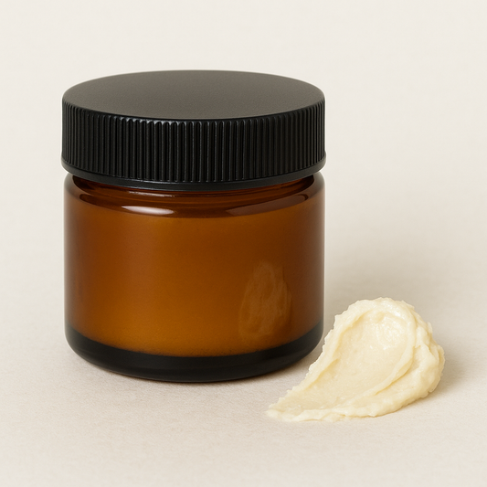 Amber glass jar filled with natural deodorant, shown beside a soft smear of product on a light neutral background
